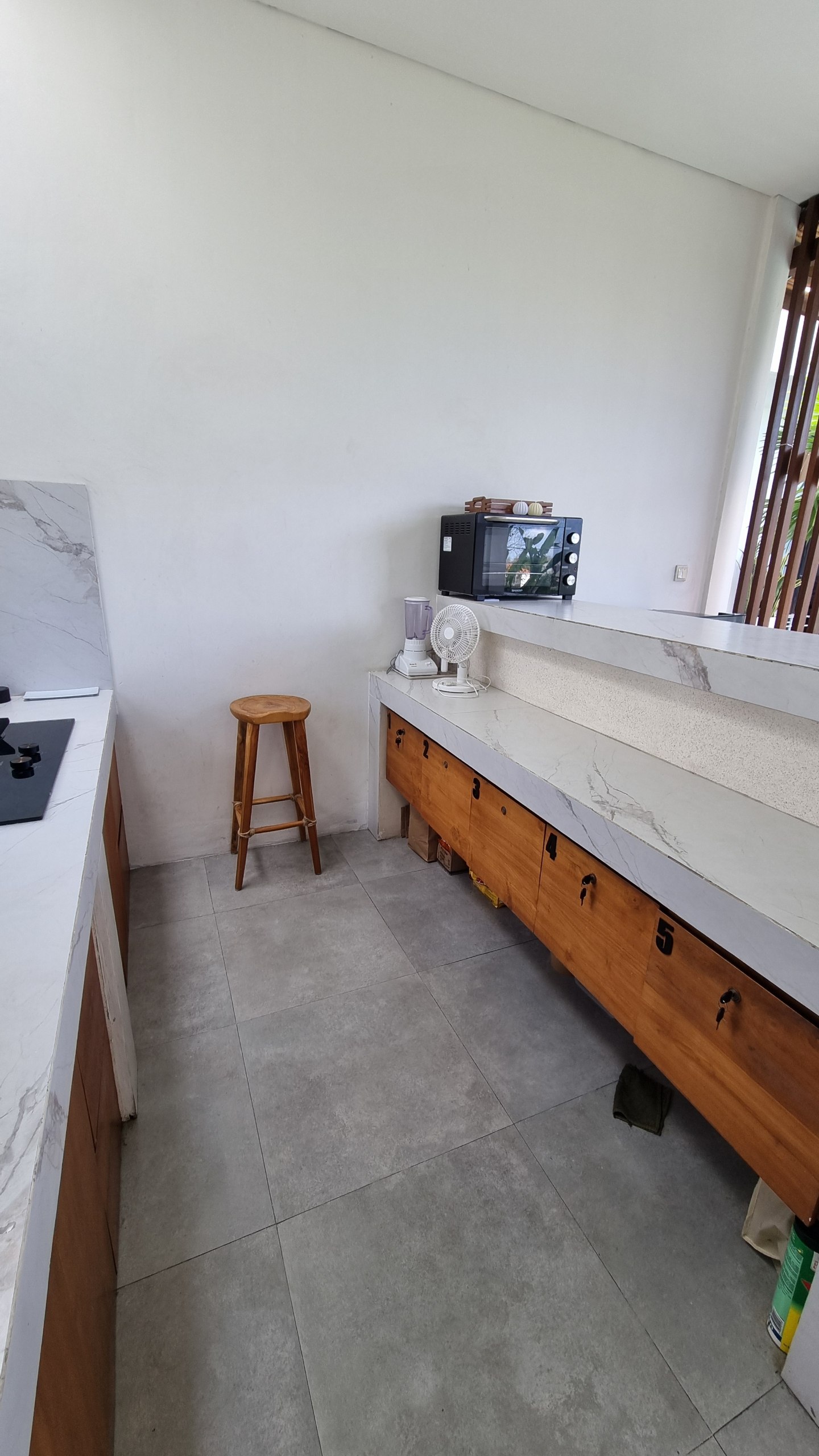 Shared kitchen counter with numbered lockable drawers and a teak stool