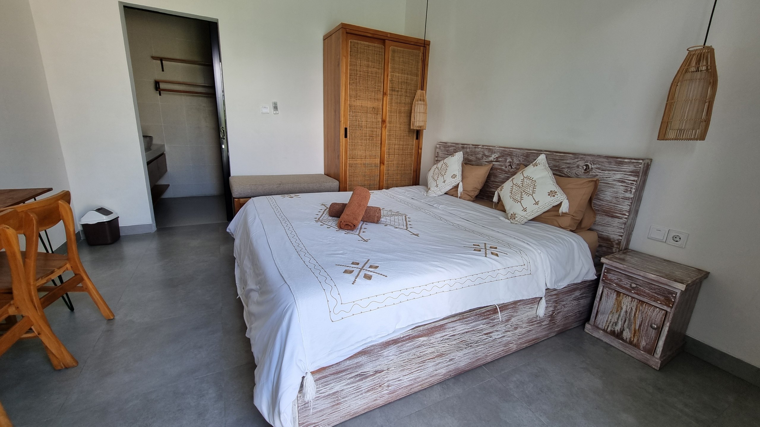 Private room with a double bed, rattan wardrobe and ensuite doorway